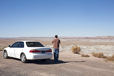 USA, Arizona, Painted Desert. Little Painted Desert, Man standing near car and looking at view