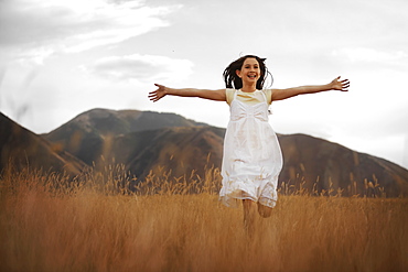 Girl (10-11) running through wheat field