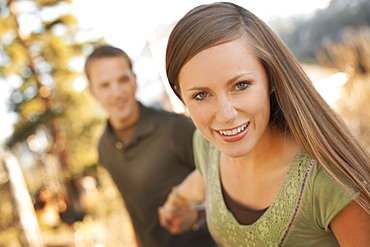 Woman pulling boyfriend by the hand