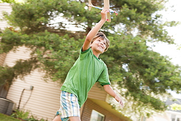 Young boy running with toy airplane