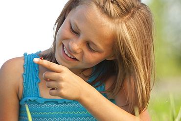 Young girl looking at a ladybug