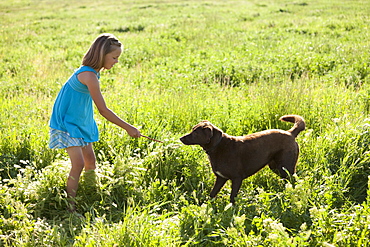 Young girl playing with her dog