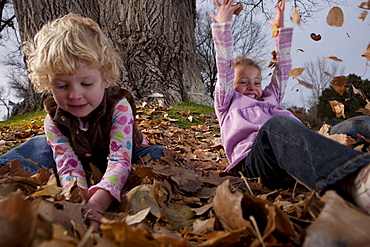 Girls playing in leaves