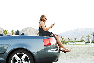 Woman sitting on car