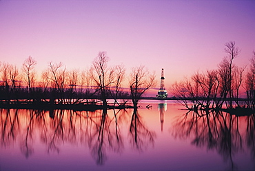 Oil platform in distance at sunset, Louisiana