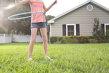 Girl hula hooping in backyard