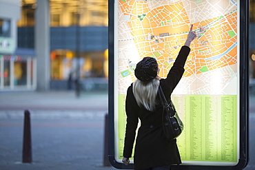 Young woman pointing at city map