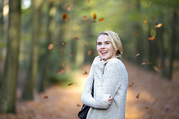 Portrait of smiling woman while leaves falling