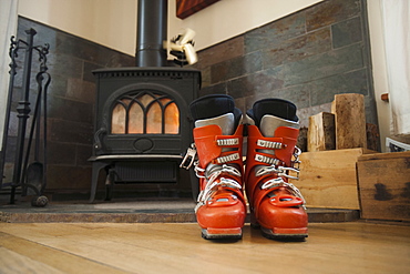 Ski boots drying in front of fireplace