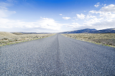 Road going through desolate landscape, Wyoming, USA
