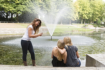 Female friends using cell phone, Netherlands, Groningen