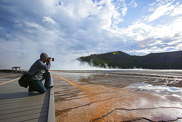 Man photographing Grand Prismatic Geyser, USA, Montana