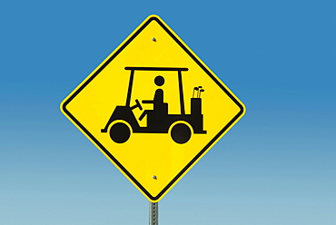 Yellow road sign depicting golf cart