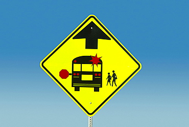 Warning sign against blue sky