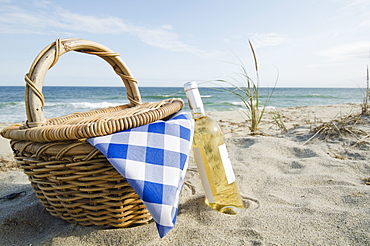 Picnic basket and white wine on beach