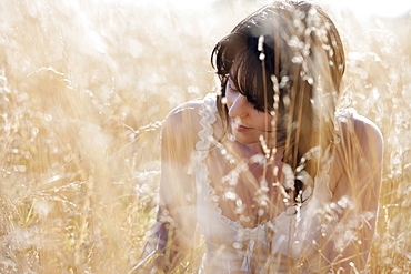 Young woman sitting on cornfield