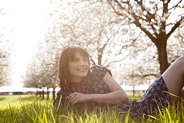 Belgium, Sint-Truiden, Portrait of young woman in spring orchard, Belgium, Sint-Truiden