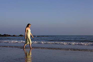 France, Pas-de-Calais, Escalles, Young woman strolling on empty beach, France, Pas-de-Calais, Escalles