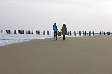 France, Pas-de-Calais, Escalles, Two women strolling on empty beach, France, Pas-de-Calais, Escalles