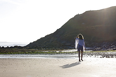 France, Pas-de-Calais, Escalles, Young woman strolling on empty beach, France, Pas-de-Calais, Escalles