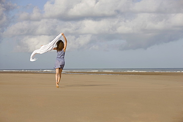 France, Pas-de-Calais, Escalles, Young woman strolling on empty beach, France, Pas-de-Calais, Escalles