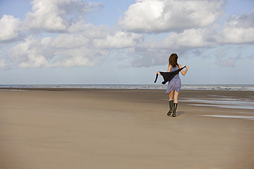 France, Pas-de-Calais, Escalles, Young woman strolling on empty beach, France, Pas-de-Calais, Escalles