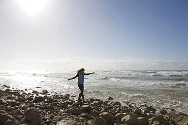 France, Pas-de-Calais, Escalles, Young woman strolling on rocky beach, France, Pas-de-Calais, Escalles