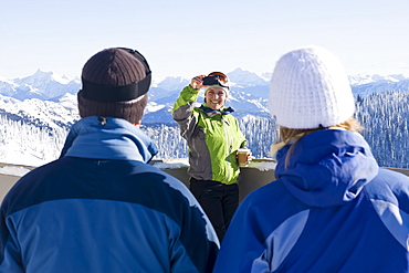 USA, Montana, Whitefish, Woman photographing friends in mountain resort