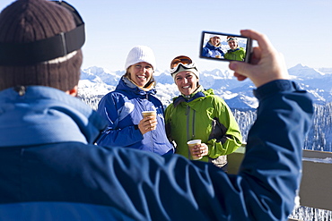 USA, Montana, Whitefish, Man photographing two women in mountain resort