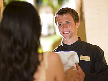 Man from room service delivering towels to hotel guest