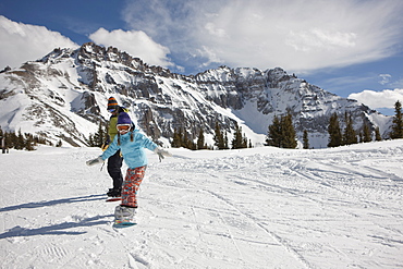 USA, Colorado, Telluride, Father and daughter (10-11) snowboarding 