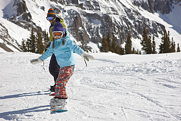 USA, Colorado, Telluride, Father and daughter (10-11) snowboarding 