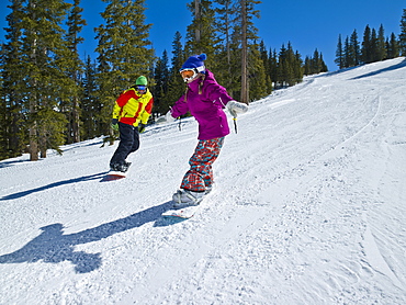 USA, Colorado, Telluride, Father and daughter (10-11) snowboarding 