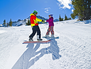 USA, Colorado, Telluride, Father and daughter (10-11) snowboarding 