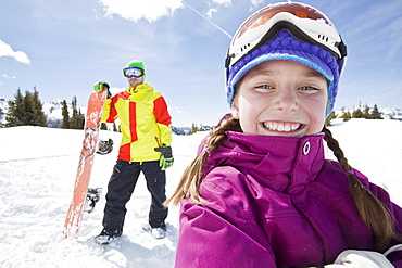 USA, Colorado, Telluride, Father and daughter (10-11) posing with snowboards in winter scenery