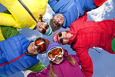 Three-generation family with girl (10-11) posing during ski holiday