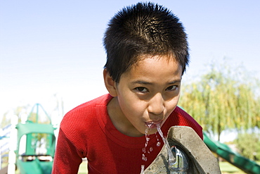 Boy (12-13) at drinking fountain