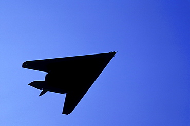 Silhouette of military plane flying against blue sky, Holland