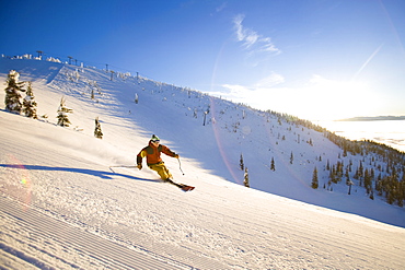 USA, Montana, Whitefish, Male skier on mountain slope at sunrise