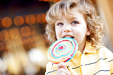 USA, California, Los Angeles, Boy (4-5) holding lollipop and looking away