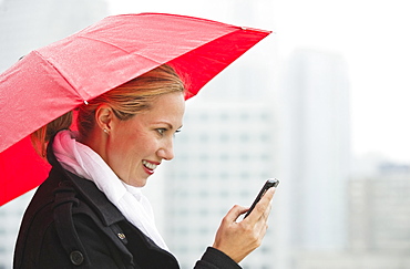 Woman texting on a rainy day