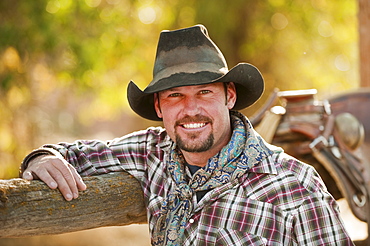 Cowboy leaning on fence