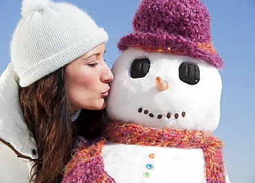 Woman kissing snowman