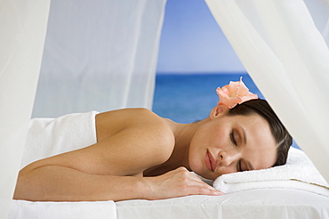 Woman laying on massage table with ocean in background