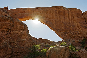 Sun shining behind South Window Arch in Arches National Park, Utah