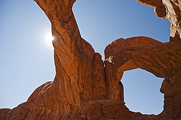 Sun shining behind Double Arch of Arches National Park, Utah