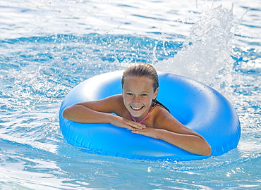 Girl playing with inflatable tube in swimming pool