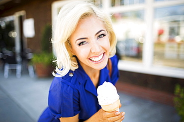 Portrait of smiling woman with ice-cream, Costa Mesa, California