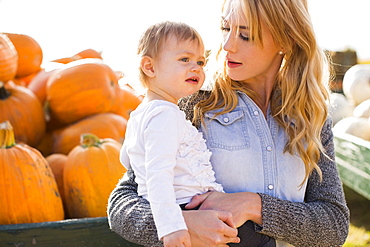 Mother and daughter (12-17 months) with pumpkins in background