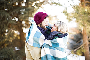 Couple wrapped in blanket hugging outdoors, Salt Lake City, Utah